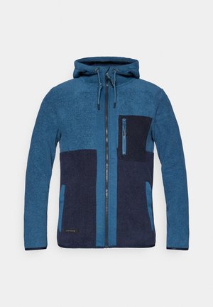 Casaco de polar azul com seções contrastantes em azul marinho, capuz, fecho frontal e bolso no peito. Apresenta tecido texturizado e cordões ajustáveis.
