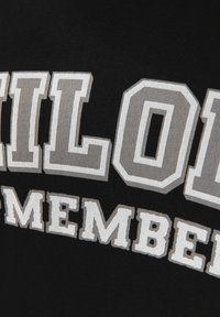 Mustapohja, jossa on suurta, koholla olevaa harmaata ja valkoista tekstiä, joka lukee "PILOT" ja "MEMBER". Tekstillä on kulmikas, yliopistotyyppinen fontti.