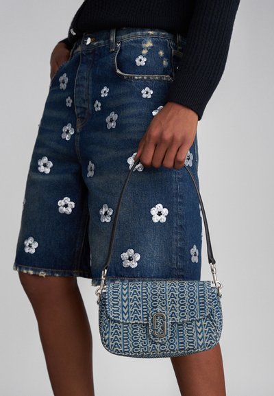 Blå denim skulderveske med et mønstret design, som har et beslag i sølvfarge og en slank svart stropp. Detaljert med geometriske aksenter.