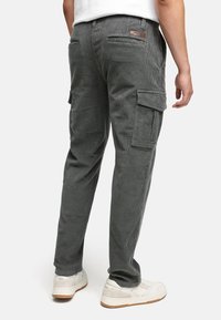 Grå corduroy cargo bukser med slim fit, har to sidelommer, baklommer og et lærlabel på midjen.