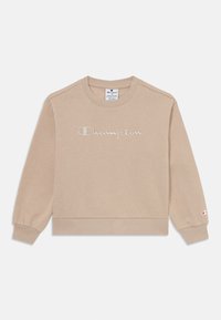 Sweatshirt beige clair à manches longues, avec des poignets et un ourlet côtelés, présentant le logo brodé "Champion" en script sur la poitrine. Mélange de coton doux.