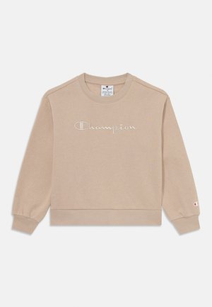 Light beige sweatshirt with long sleeves, ribbed cuffs and hem, featuring stitched "Champion" script logo across the chest. Soft cotton blend.