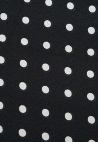 Czarna tkanina z równomiernie rozmieszczonymi białymi kropkami, tworzącymi powtarzający się wzór.