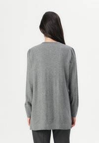 Gray knitted sweater with a ribbed texture, long sleeves, and a straight hem. Features subtle vertical herringbone patterns on the back.
