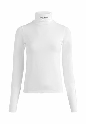 Valkoinen pitkähihainen poolopaita, jossa "Calvin Klein Jeans" -teksti kauluksen kohdalla, esitetty yksinkertaisella taustalla.