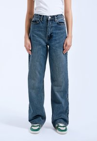 Blauwe high-waisted denim jeans met een relaxte pasvorm, voorzien van een klassiek vijf-pocket ontwerp, subtiele vervaging en een ritssluiting.