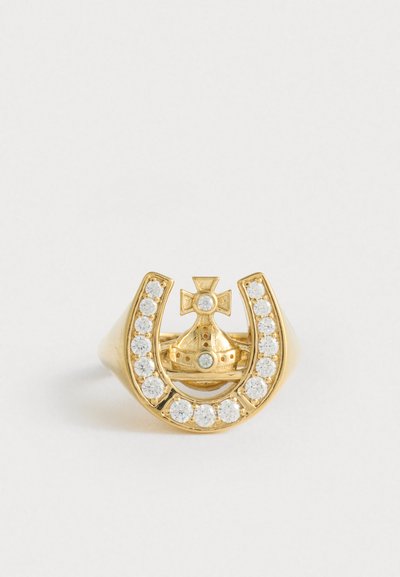 Kultainen sormus, jossa on hevosenkenkä, joka on koristeltu kirkkailla kivillä, ympäröimässä kruunua, jossa on risti, yksinkertaista valkoista taustaa vasten.