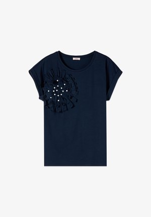 Camicia blu navy a maniche corte con scollo rotondo e dettaglio di fiore in tessuto con piccole perline bianche sul petto sinistro.