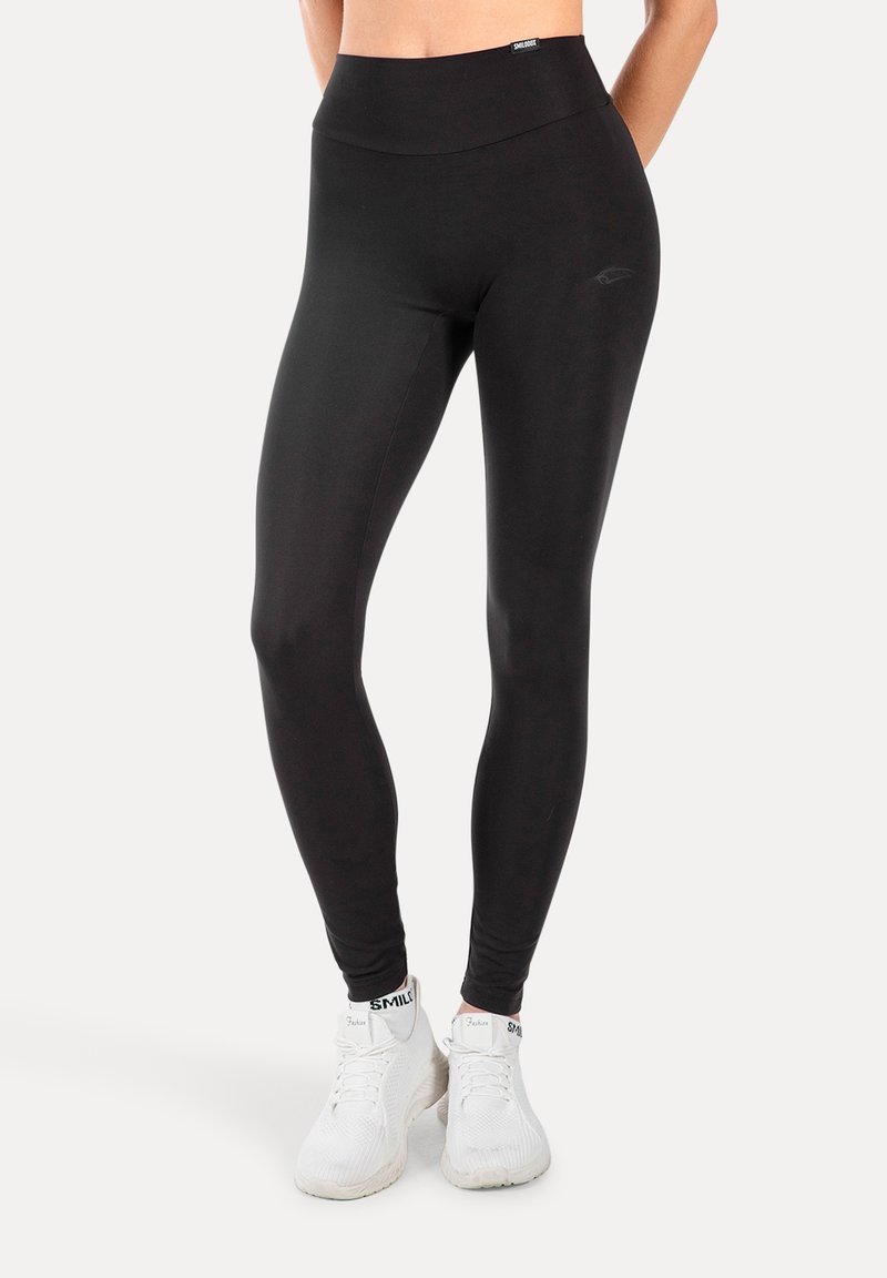 Leggings negros de cintura alta hechos de un material elástico y suave. Presenta un logotipo sutil en la cintura y un ajuste entallado a lo largo de las piernas.