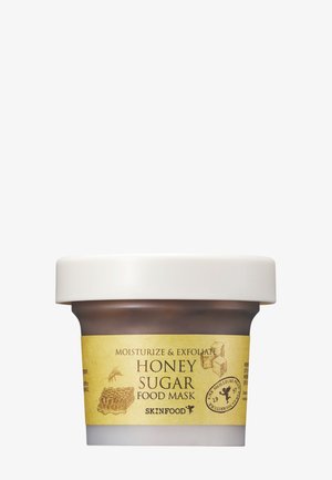 Frasco de mascarilla Skinfood Honey Sugar Food para hidratar y exfoliar con ilustraciones de panal de abeja y cubo de azúcar en la etiqueta.