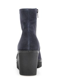 Bottine en velours côtelé marine avec une texture lisse, un talon épais noir et une fermeture éclair sur le côté pour un accès facile. Design épuré avec un minimum de détails.