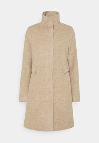 Abrigo beige con cuello alto, bolsillos frontales y un diseño ajustado. Hecho de tela texturizada, hasta la rodilla y con una silueta recta.