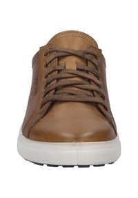 Brown leather sneaker with round toe, white rubber sole, and brown laces. Features stitching details along the edges and metal eyelets.