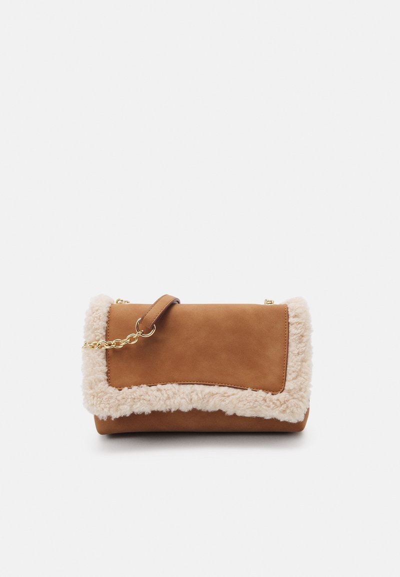 Bolso de ante marrón con un lujoso ribete de piel sintética crema. Cuenta con una correa de cadena dorada y un diseño de solapa plegable. Textura suave y forma redondeada.