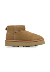 Bruine suède enkellaars met een ronde neus, versterkte stiksels en een geprofileerde rubberen zool. Voorzien van een achterste trekband en logoaccent.