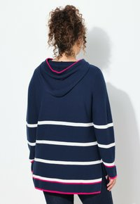 Granatowy sweter z kapturem w białe poziome paski, z różowymi akcentami przy kapturze i u dołu. Miękka dzianina, luźny krój.