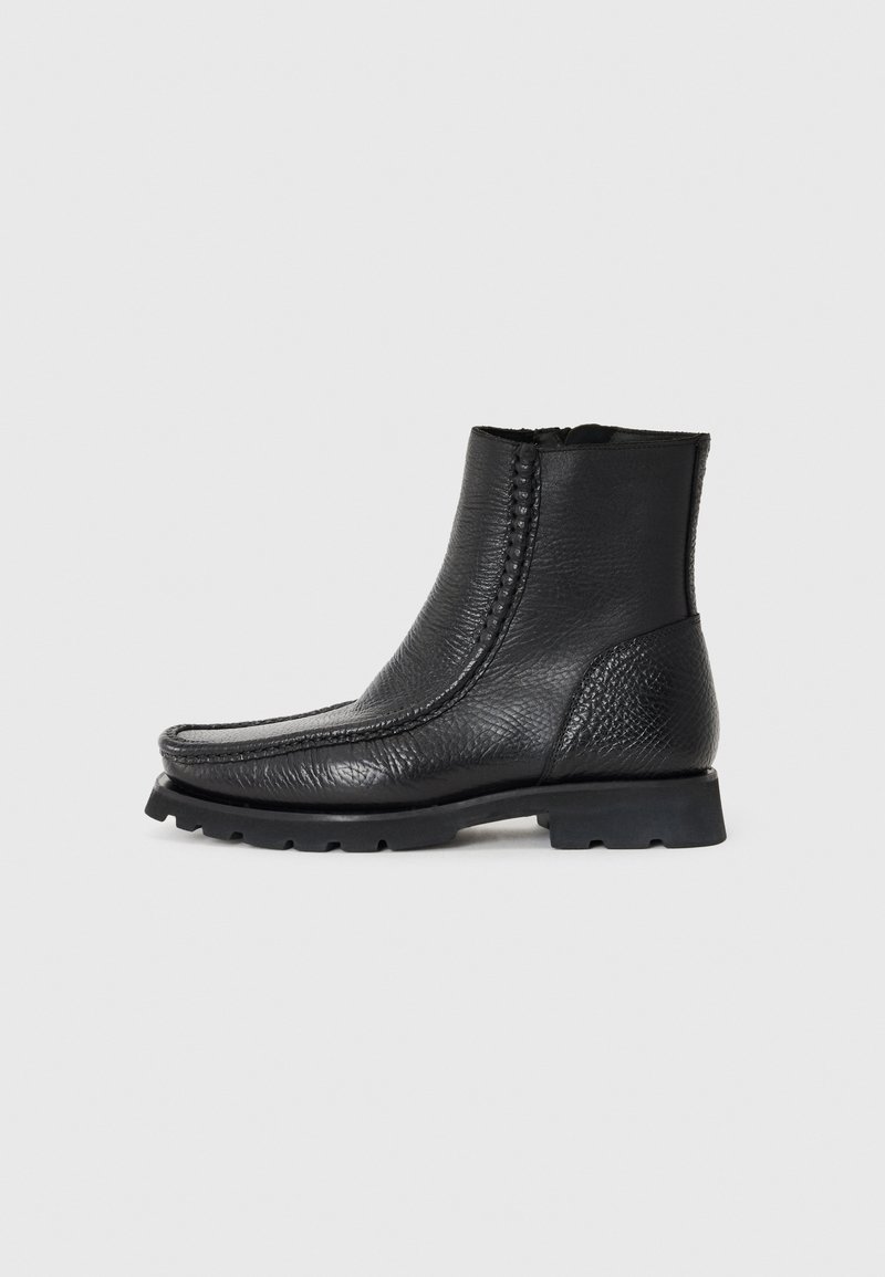 Schwarze Leder-Stiefeletten mit strukturiertem Finish, runder Zehenpartie, seitlichen Nähten und robuster Gummisohle.
