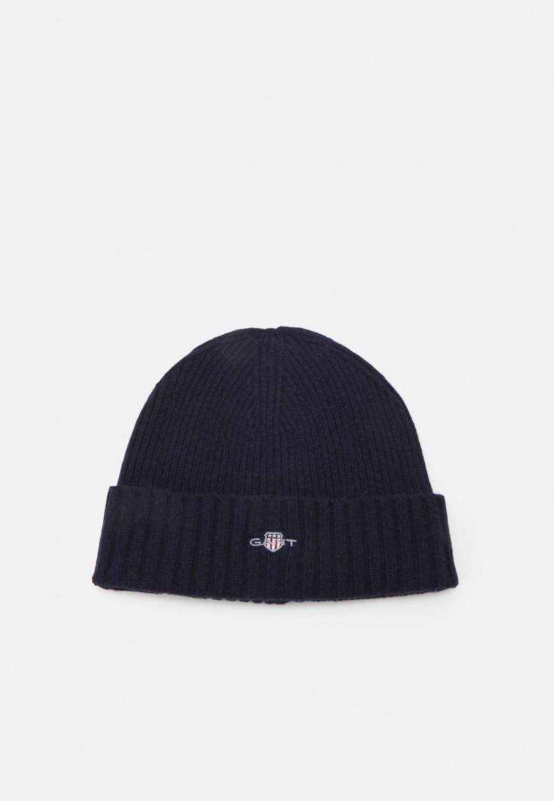 Navy knitted beanie with ribbed texture, fold-over cuff, and small embroidered logo in contrasting colors on front.
