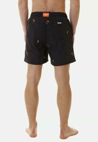 Pantaloni da nuoto neri con motivi colorati di fenicotteri e a tema spiaggia. Vita elastica con un'etichetta arancione del marchio e due tasche laterali.
