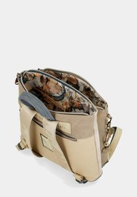 Borsa beige con più scomparti con cerniera, un esterno testurizzato e un rivestimento a motivo floreale. Include una tracolla regolabile e dettagli decorativi.