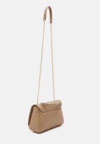 Quilted beige handbag with a top handle and gold chain. Rectangular shape with a textured surface and a flap closure.