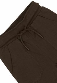 Bruine katoenen sweatpants met een geribde tailleband, een trekkoord en twee zijzakken. Soepele textuur met zichtbare stiksel-details.