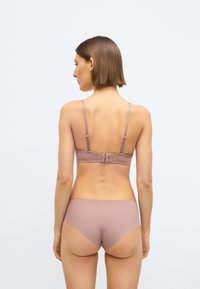 Lys mauve bh med justerbare stropper og hægte-lukning, kombineret med matchende høj talje trusser. Glat tekstur, minimalistisk design.