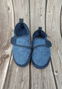 Vilt slippers in verschillende tinten blauw met donkerblauwe accenten, ronde neus, klittenbandriem en een zachte, gestructureerde afwerking.