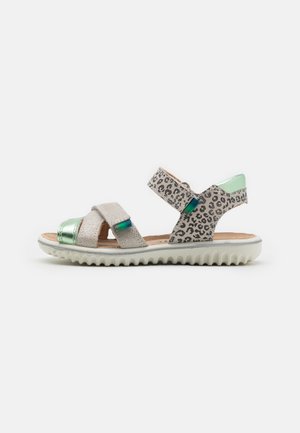 Sandales à lanières avec un imprimé léopard et des accents métalliques argentés, dotées d'un dessus en texture douce et d'une semelle blanche striée.