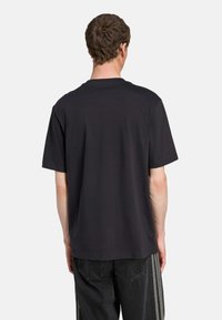 Sort kortærmet t-shirt med rund hals, lavet af bomuld. Casual pasform med en glat overflade og uden synlige mønstre eller grafikker.