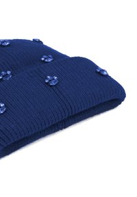 Cappello lavorato a maglia di colore blu navy con texture a coste, decorato con piccole decorazioni a forma di fiore blu sparse sulla superficie.