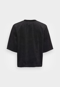 Svart kortärmad topp gjord av mjukt, mockaliknande material. Har en avslappnad passform och rund halsringning, med minimala sömmar och inga synliga mönster.