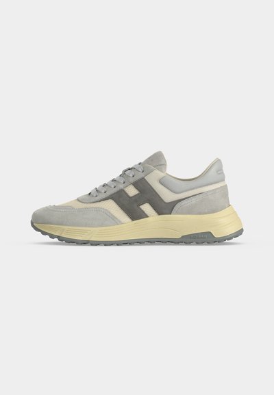 Baskets en daim gris clair et beige avec logo gris "H" sur le côté et semelle couleur crème sur fond blanc, vues de profil gauche.