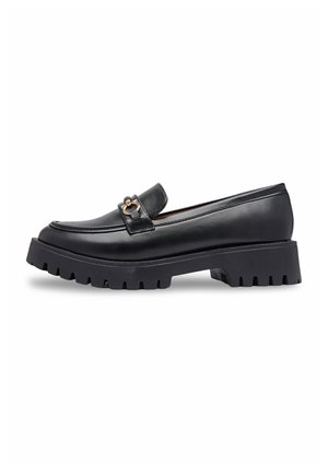 Mocassins en cuir noir avec une semelle texturée épaisse, dotés d'un lien décoratif doré sur le dessus et d'une silhouette élégante.
