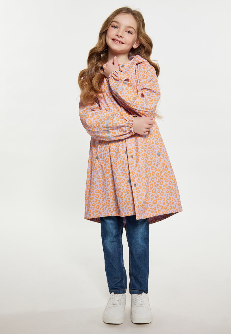 Roze kišni kaput s narančastim leopard uzorkom, kapuljača, elastične rukave i rašireni kroj, uparen s plavim trapericama i bijelim tenisicama.