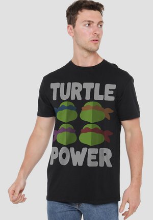 Black cotton t-shirt featuring a graphic of green turtles and the text "TURTLE POWER" in bold gray letters.