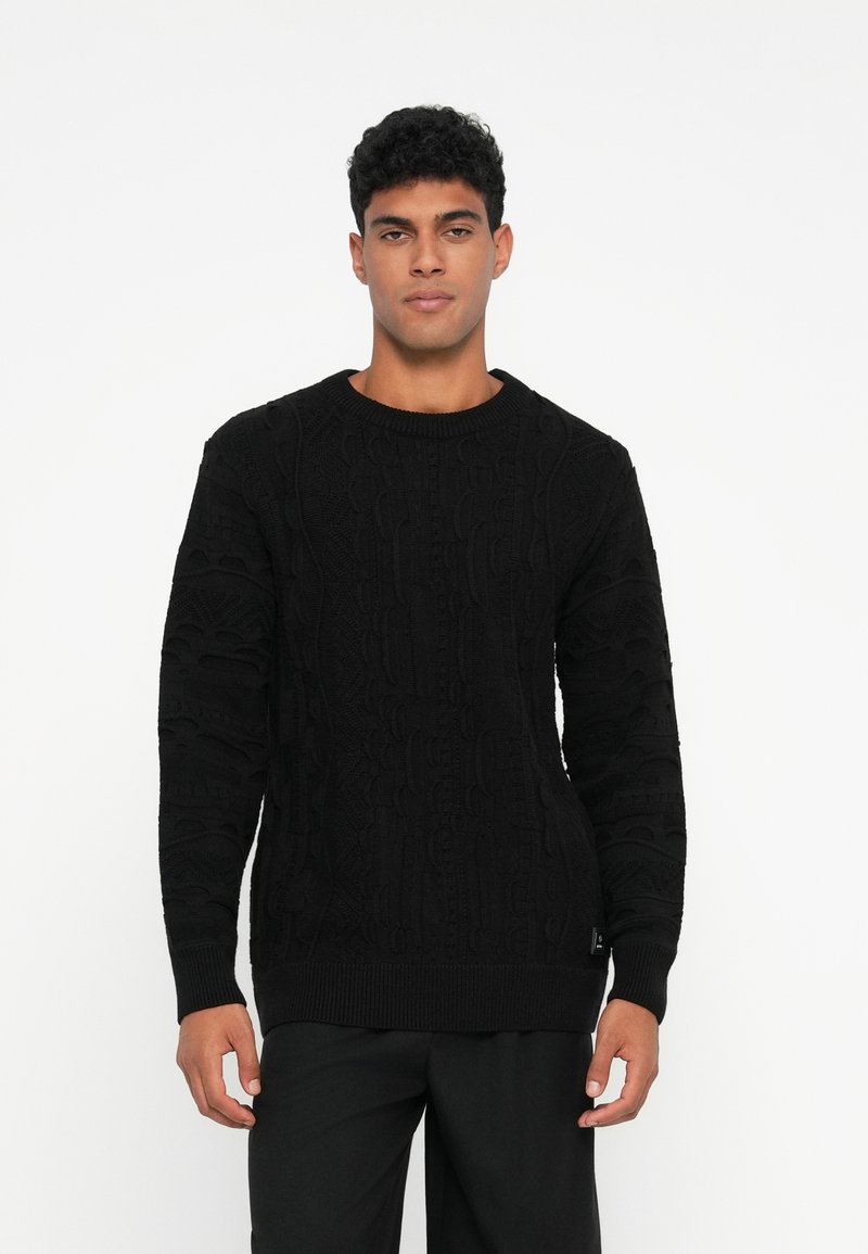 Schwarzer Strickpullover mit strukturiertem Muster, Rundhalsausschnitt und langen Ärmeln. Aus weichem Material mit gerippten Ärmeln und Saum.