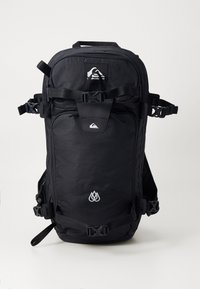 Black backpack with textured fabric, multiple adjustable straps, a front zip pocket, and white logo accents. Compact design for outdoor use.