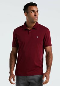 Bordeaux polo shirt gemaakt van ademend materiaal, met een klassieke kraag, korte mouwen en een klein geborduurd logo op de borst.