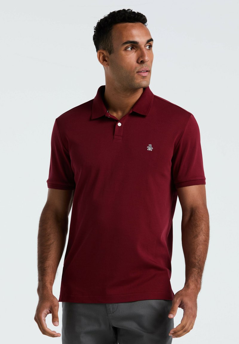 Bordeaux polo shirt gemaakt van ademend materiaal, met een klassieke kraag, korte mouwen en een klein geborduurd logo op de borst.