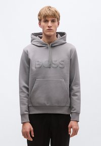 Hall halli, millel on esipõll, lukuga kapuuts ja reljeefne "BOSS" logo. Valmistatud pehmest kangast, millel on soonilised varrukasäärised ja alläär.