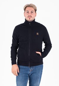 Cardigan zip-up nero con colletto alto, polsini e orlo a coste, caratterizzato da una piccola etichetta con logo sul petto. Tessuto in maglia morbida.
