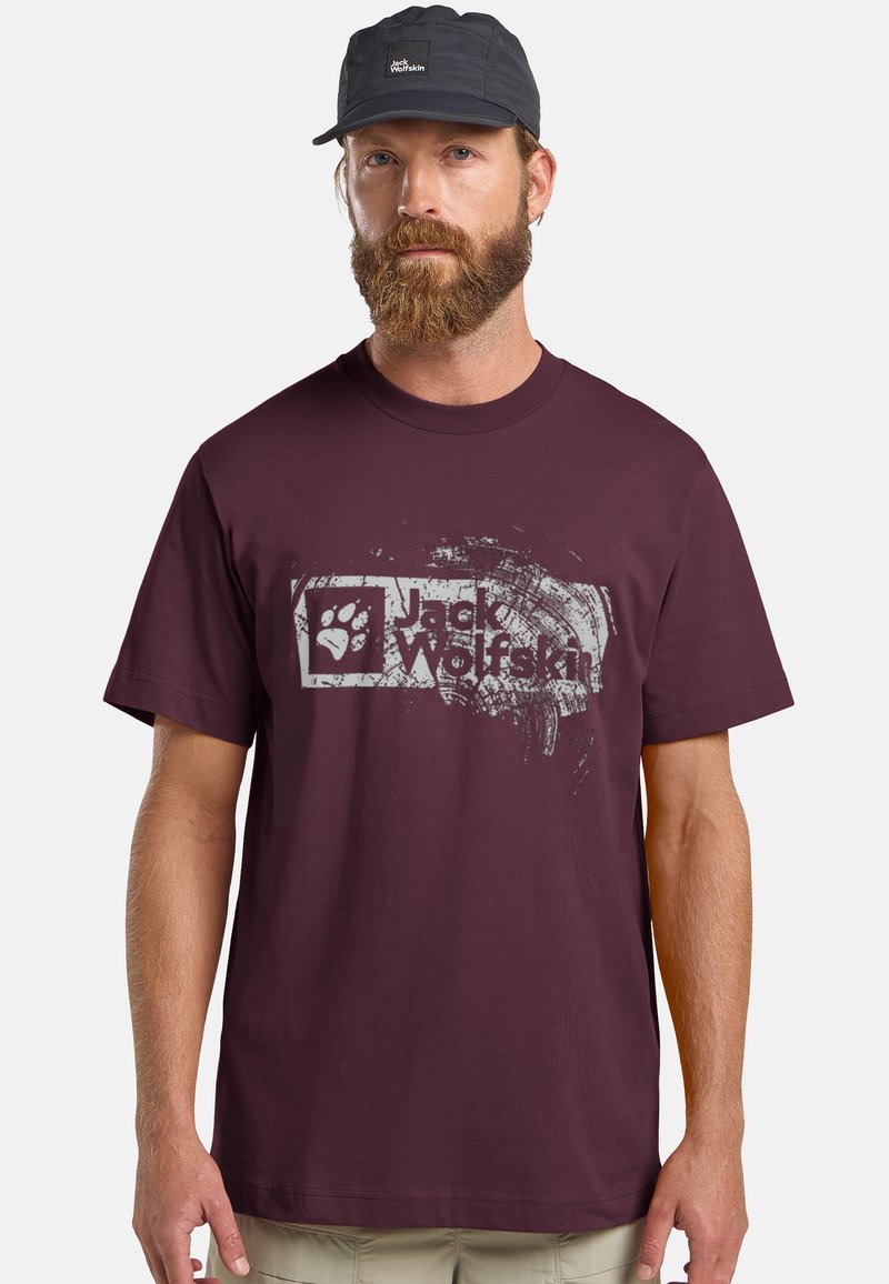 Bordeaux katoenen t-shirt met een versleten witte afbeelding van een pootafdruk en de tekst "Jack Wolfskin". Korte mouwen, ronde hals.
