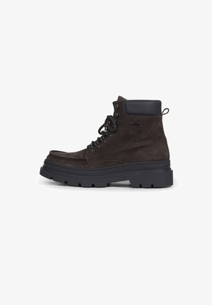 Dunkelbrauner Wildleder-Stiefelette mit schwarzem gepolstertem Kragen, schwarzer dicker Gummisohle und schwarzen Schnürsenkeln auf weißem Hintergrund.