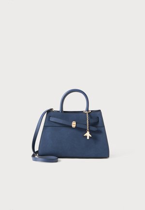 Sac à main en daim bleu marine avec une forme structurée, des accessoires en métal doré, un accent en nœud et une bandoulière détachable.