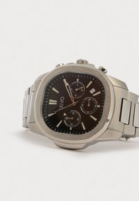 Hopeakylkinen chronograph-kello mustalla kellotaululla, kolmella alataululla ja harjatulla hihnalla. Varustettu näyttävällä kehällä ja tuntimerkeillä.