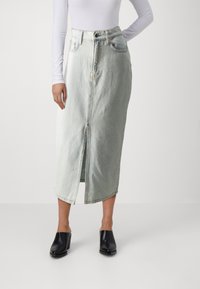 Lysvasket denimskjørt med frontsliss, høyt liv og to frontlommer. Glatt tekstur, rett snitt og sydd kantdetalj.
