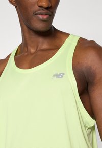 Αθλητικό τοπ χωρίς μανίκια σε ανοιχτό πράσινο χρώμα με ραβδωτή υφή. Φέρει μικρό γκρι λογότυπο New Balance στην αριστερή πλευρά του στήθους.