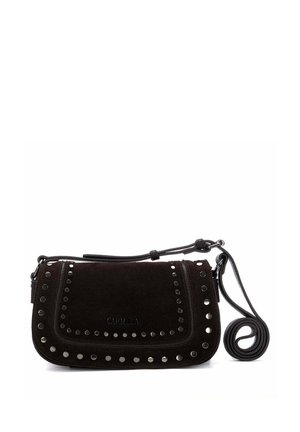 Bolso bandolera de ante negro con tachuelas plateadas a lo largo de los bordes de la solapa y una correa de hombro ajustable, con la marca "Carmela" en la solapa frontal.