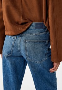 Farkut keskimetsäisin sinisin sävyin, klassisella viiden taskun muotoilulla. Ominaisuudet suora lahje, hillitty ompelu sekä brändätty patch takavyötäröllä.